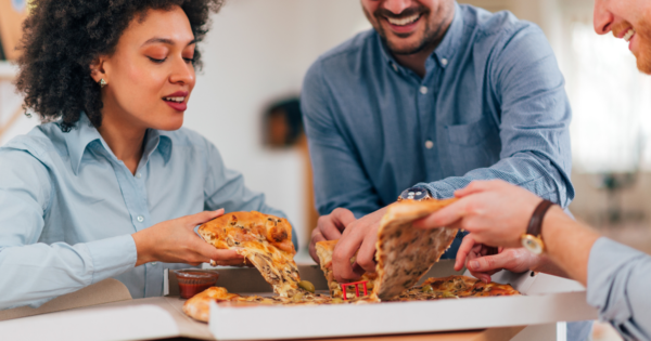 Personen die sich eine Pizza teilen